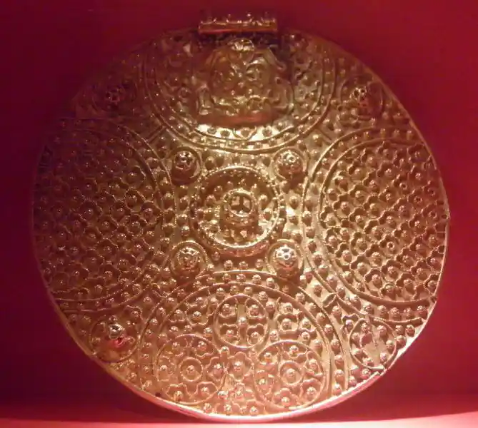 Gold solar disc ornament with dotted texture
